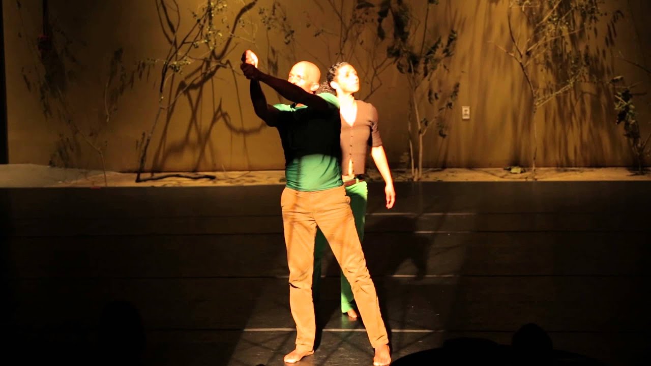 Two dancers performing The Artist Struggle on a warmly lit stage