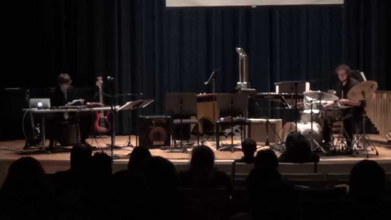 A drummer and computer performer presenting Seismograph on a recital stage